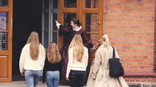Nuoria naisia astumassa sisään museoon. 